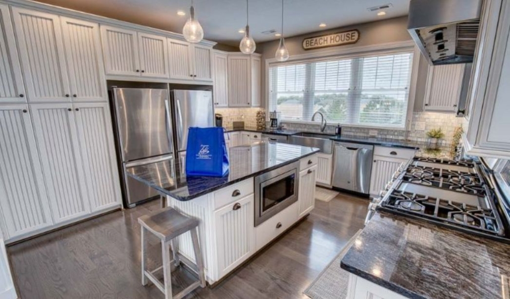 The Amazing Grace kitchen with white beadboard cabinetry, black granite, and classic and modern design