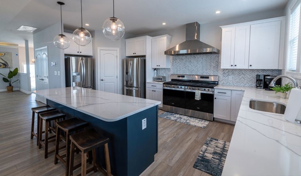 The elegant kitchen of Happy As a Clam with white quartz countertop, custom cabinetry, and contemporary design