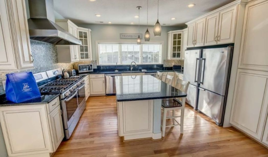 The Oh the Places You’ll Go kitchen features white cabinetry, black granite countertop, and high-end stainless steel appliances with contemporary design