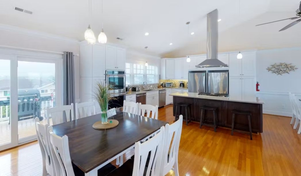 The Sandfiddler kitchen features white cabinetry, stainless steel appliances, and contemporary design