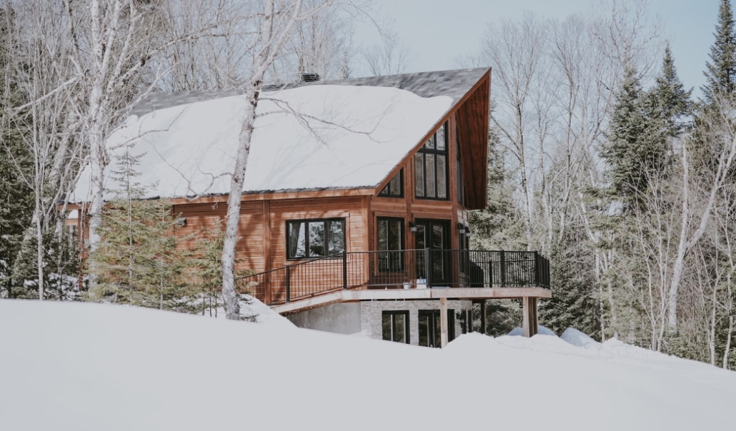 A cozy cabin nestled in a snowy forest, illustrating the importance of winter home maintenance for safety and comfort.