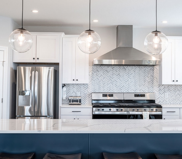 A modern kitchen featuring white cabinets and marble countertops, showcasing premium materials by Courthouse Estates, Virginia Beach.