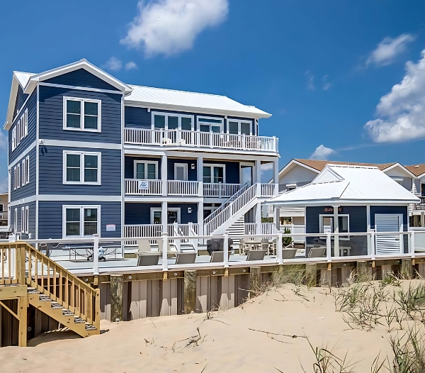 A charming beach house featuring blue and white siding, showcasing the craftsmanship of Great Neck Virginia Beach Home Builders.