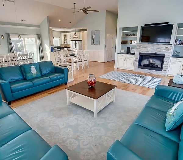 A modern living room adorned with blue couches and a television, reflecting the personal design expertise of Little Neck Virginia Beach Home Builders.