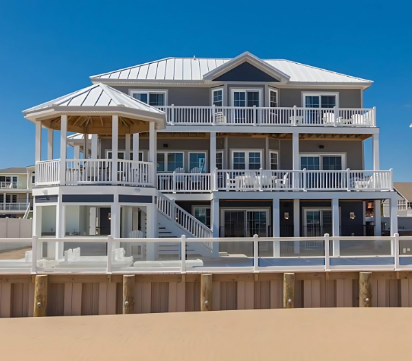 Beach house in Little Neck, Virginia Beach, showcasing a lovely balcony and deck, perfect for enjoying coastal views.