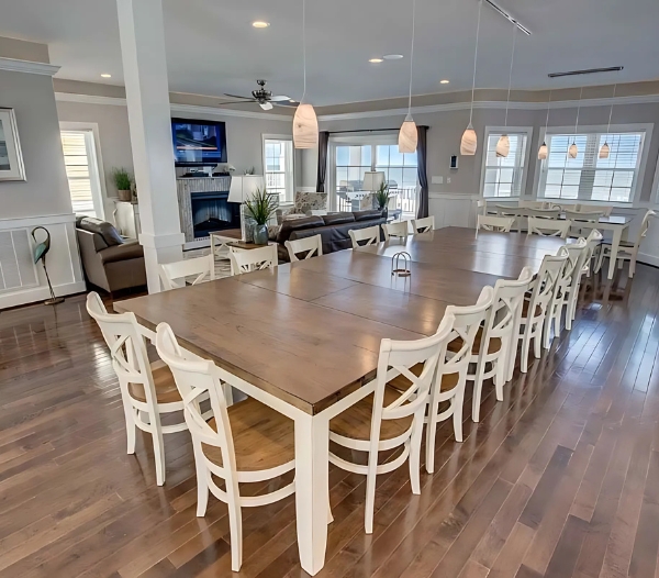 Elegant dining room with white chairs and a large table, highlighting skilled craftsmanship in home improvement in Virginia Beach.