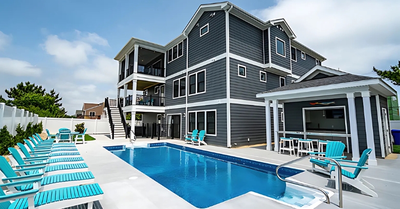 A family-friendly house in Happy As a Clam, Virginia Beach featuring a pool and blue chairs, perfect for relaxation and enjoyment.