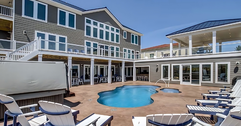 An inviting pool and deck area with stylish chairs, showcasing outdoor living in Virginia Beach custom home designs.