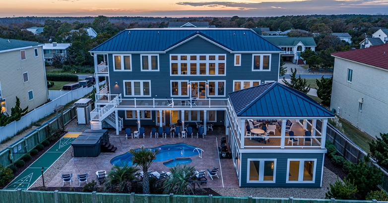 A serene home with a pool and deck, bathed in the warm hues of sunset, ideal for Virginia Beach living.