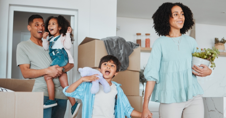 A family joyfully carrying boxes into their new home in Virginia Beach, symbolizing a fresh start and new beginnings.