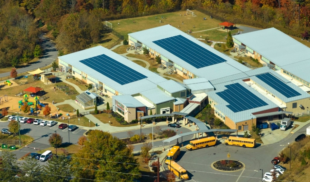 Aerial view of a Virginia Beach school featuring solar panels on the roof, highlighting sustainable energy use in education.