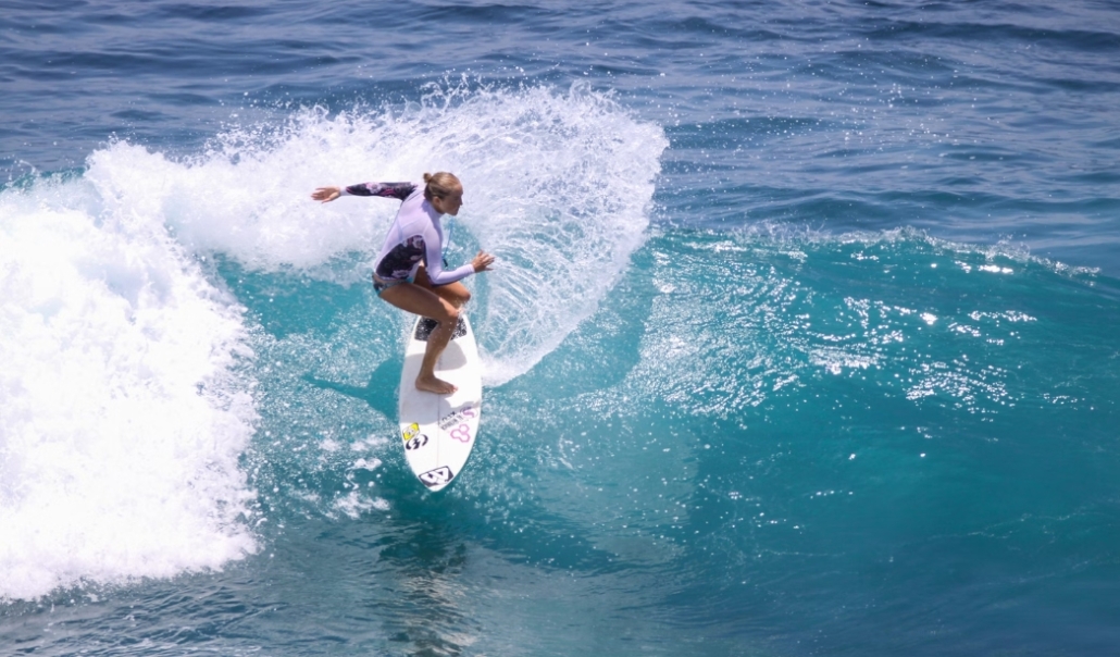 A woman surfing on a wave at Virginia Beach, highlighting the area's vibrant outdoor recreation opportunities.