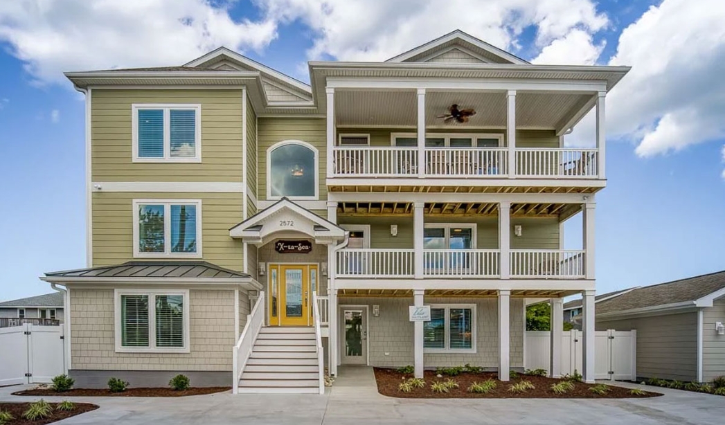 Two-story home exterior with a balcony, showcasing the design by Indian River Virginia Beach Homebuilders.