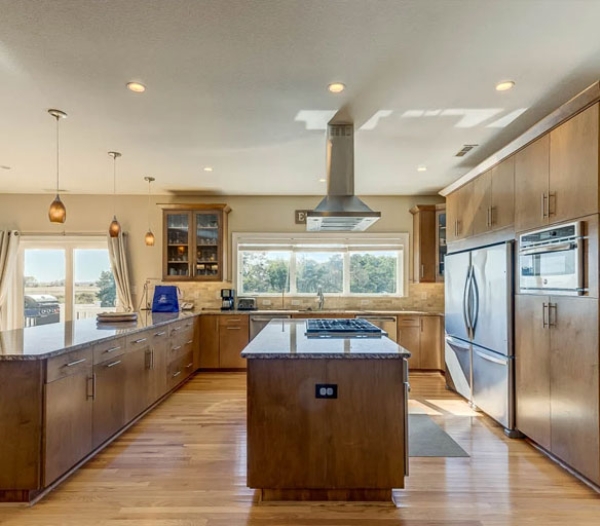 A spacious kitchen featuring wood cabinets and stainless steel appliances, showcasing high build standards by Indian River Virginia Beach Homebuilders.
