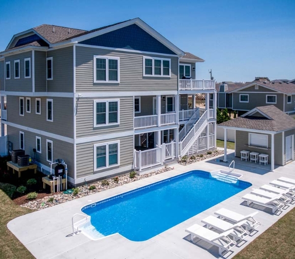 Exterior view of a house featuring a pool and decking, highlighting Indian River Virginia Beach Homebuilders' quality work.