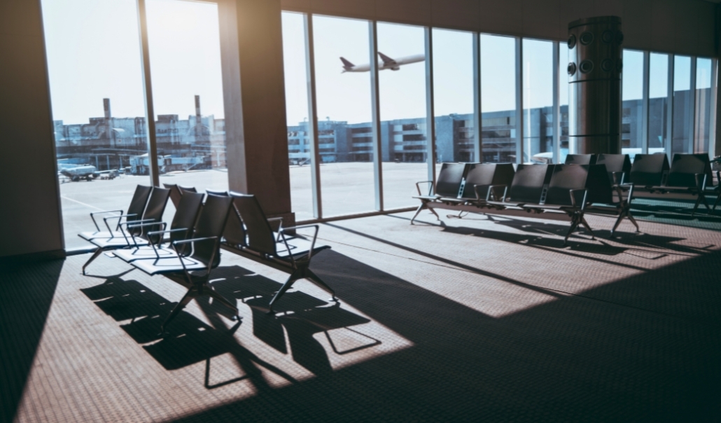 A view of empty chairs in an airport waiting area, with a plane in the background, showcasing Virginia Beach's travel facilities.