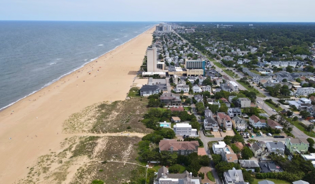 Aerial view of Virginia Beach showcasing sandy shores and nearby houses, highlighting outdoor activities and coastal living.