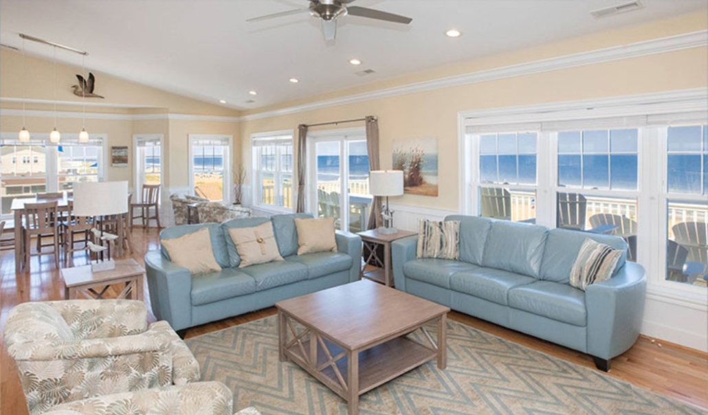 Cozy living room with blue couches and a table, showcasing energy-efficient window and door replacements in Virginia Beach.