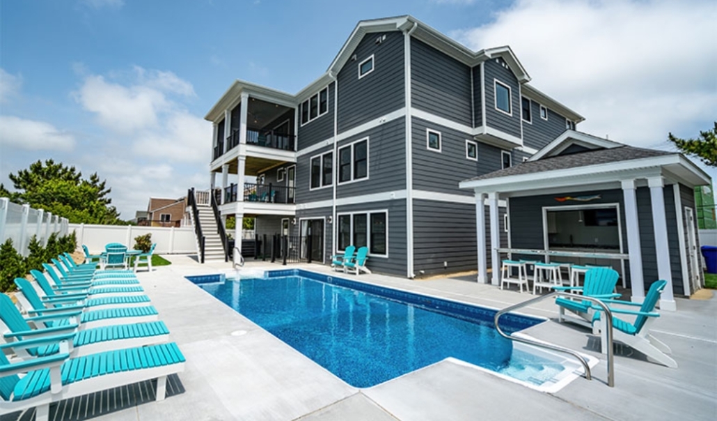 A Virginia Beach home featuring a pool and lounge chairs, showcasing outdoor living spaces for relaxation and enjoyment.