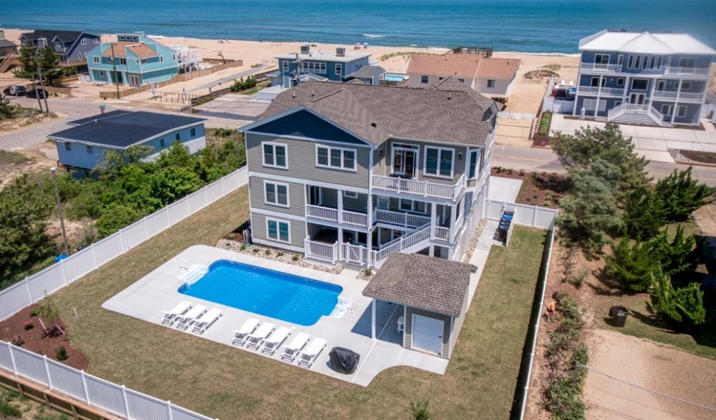 A house featuring a pool and beach view, highlighting roofing, siding, and exterior resurfacing in Virginia Beach.