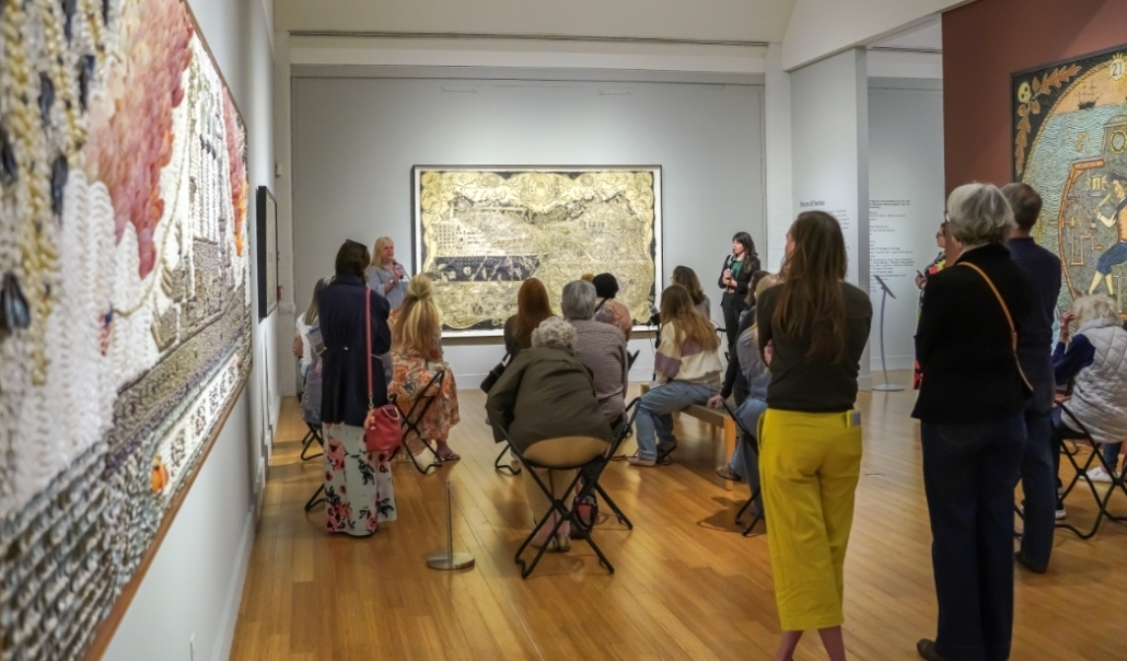 Attendees observe detailed tapestries in the Virginia Museum of Contemporary Art, emphasizing Virginia Beach's cultural scene.