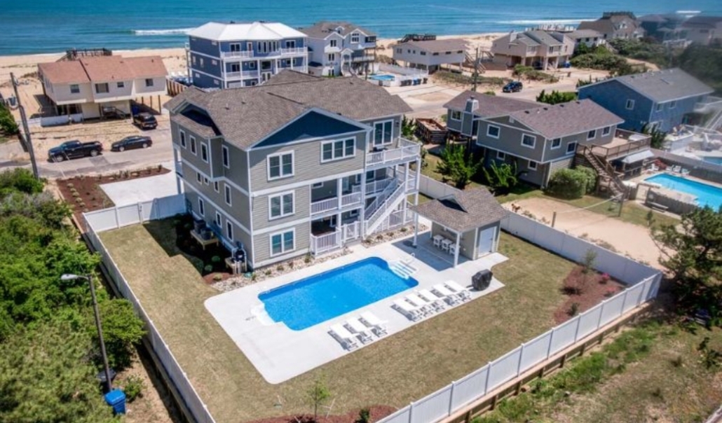 A scenic view of a house with a pool and beach, highlighting the benefits of retirement in Virginia Beach.
