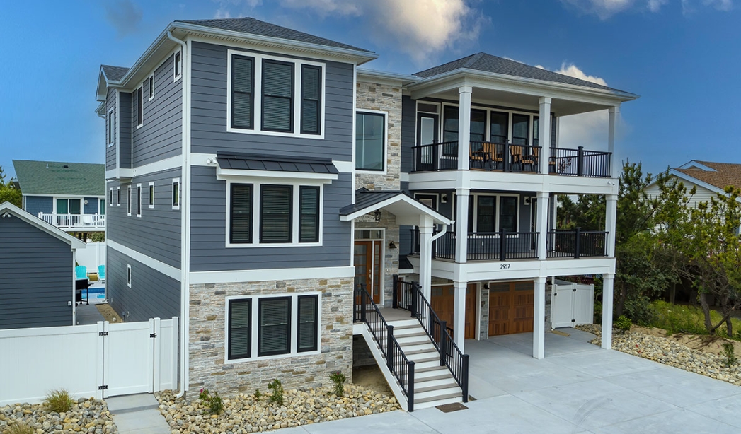 A two-story house featuring a garage and stairs, designed by Strawbridge Virginia Beach Homebuilders.