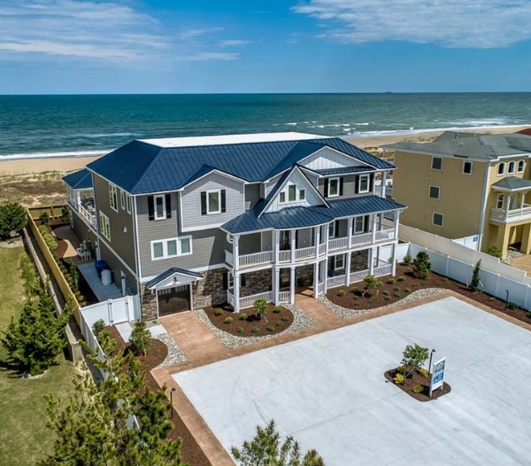 A beach house with a spacious driveway, showcasing Strawbridge Virginia Beach Homebuilders' transparent building process.