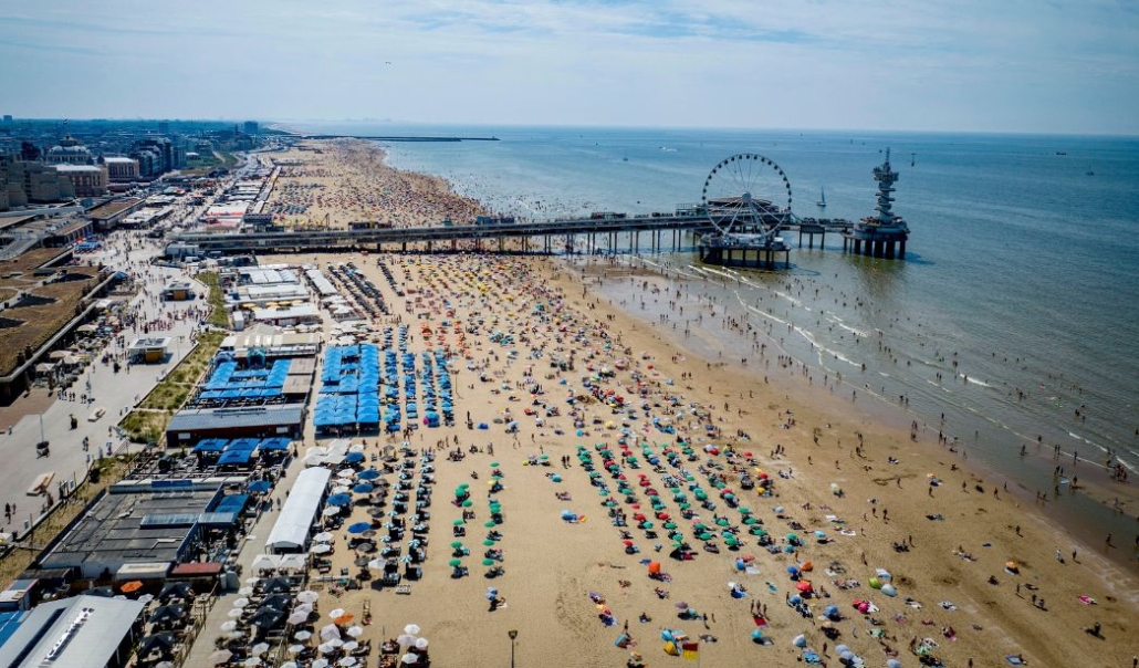 Overhead image of Virginia Beach, featuring colorful umbrellas and beachgoers on the sand.