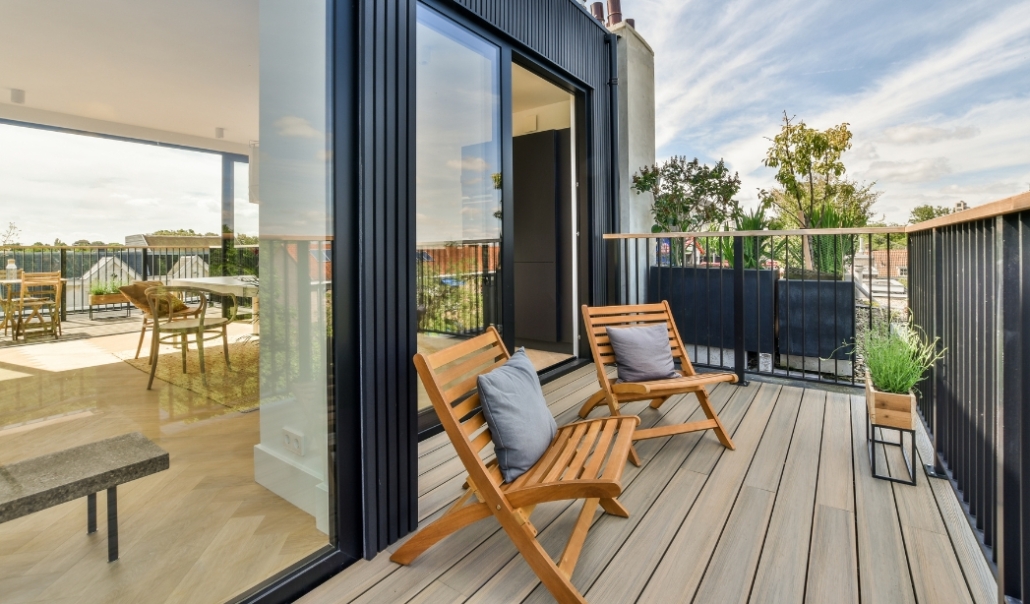Wooden chairs and a table on a balcony, highlighting the outdoor space of modular ADUs in Virginia Beach.