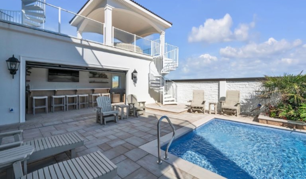 Outdoor pool and patio with a bar and grill, highlighting repurposed existing structures in Virginia Beach.