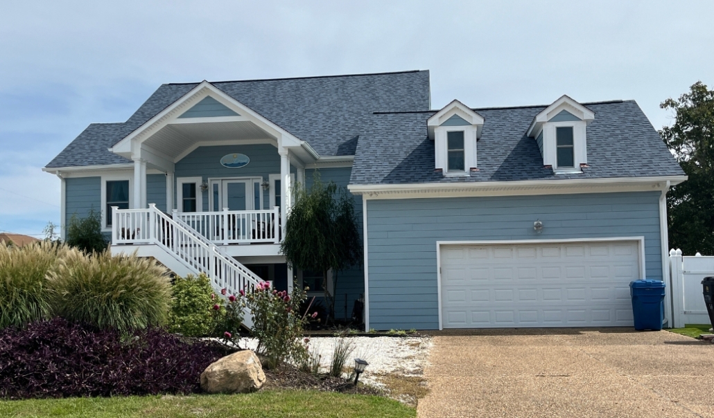 A blue house featuring a garage and a front porch, illustrating home renovation themes and potential mistakes to avoid.