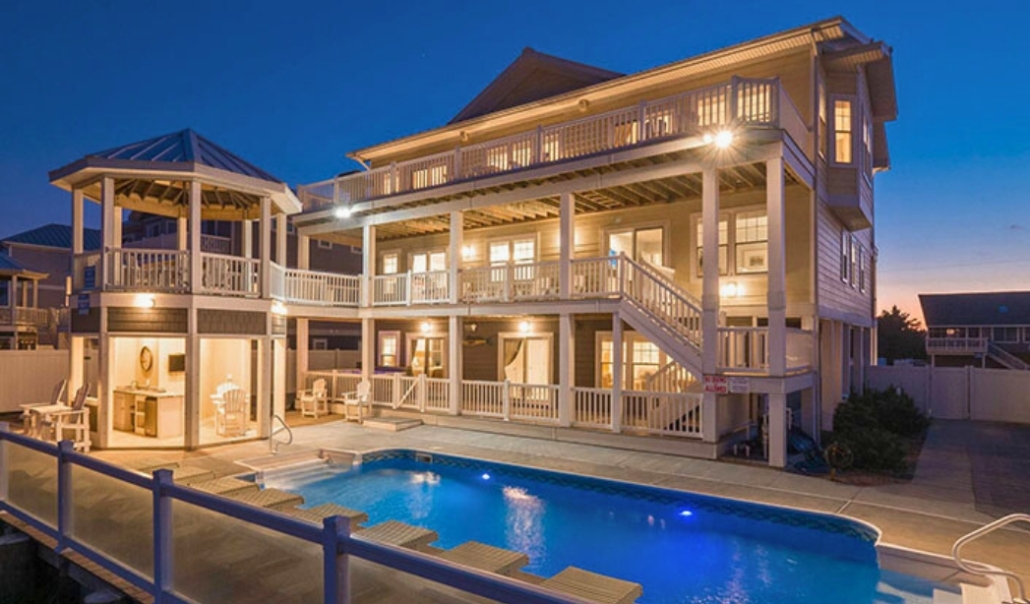 A spacious home with a pool at dusk, emphasizing the need for effective lighting in home renovation projects.