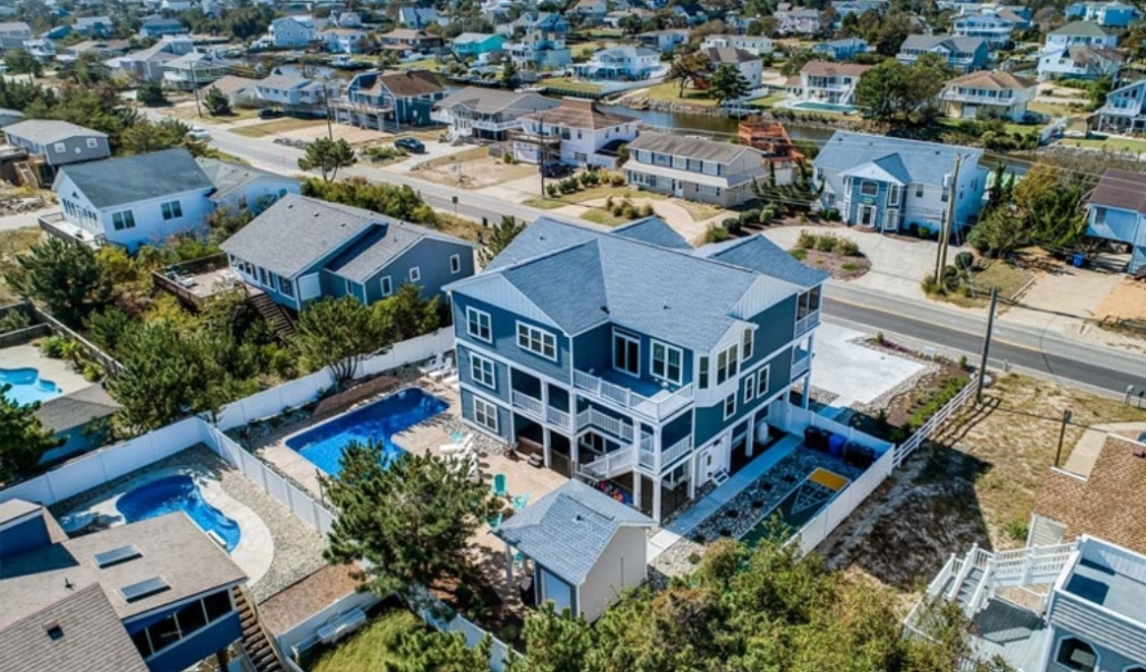 Aerial view of a beach house featuring a swimming pool, highlighting the importance of proper permits in home renovations.
