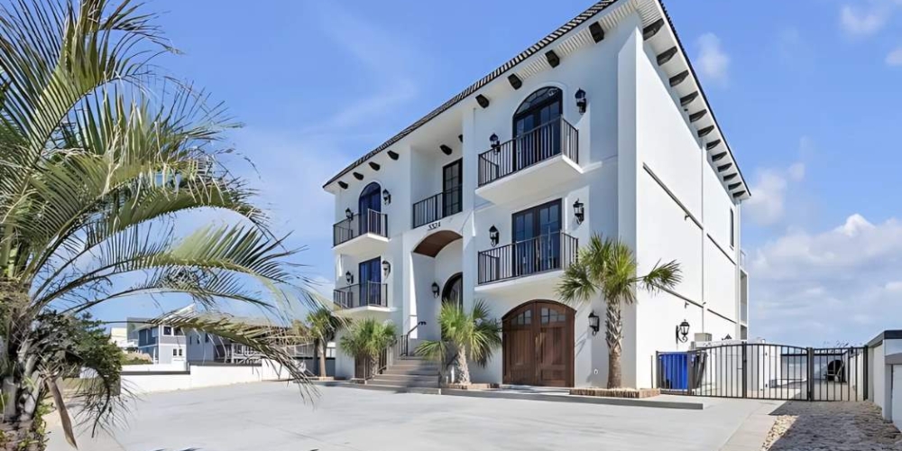 A charming white house with palm trees and a driveway, highlighting the work of Castleton Virginia Beach Home Builders.