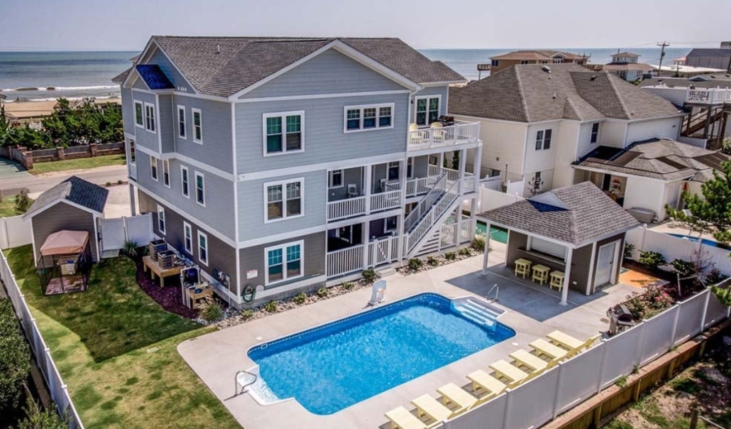 A contemporary house with a pool adjacent to a beach, showcasing effective home remodels that increase market value.