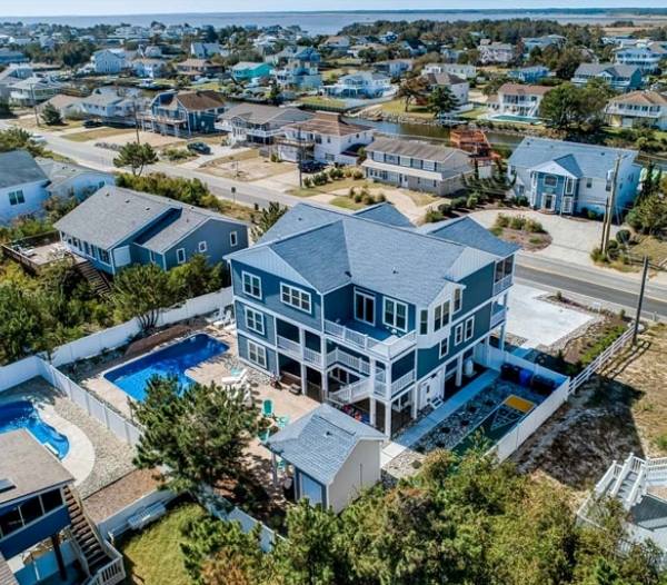Aerial view of a beach house featuring a pool, showcasing the coastal landscape of Indian River, Virginia Beach.