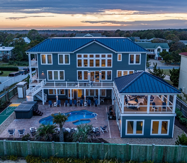 A large home with a pool and deck at sunset, showcasing coastal resilience in Kempsville, Virginia Beach.