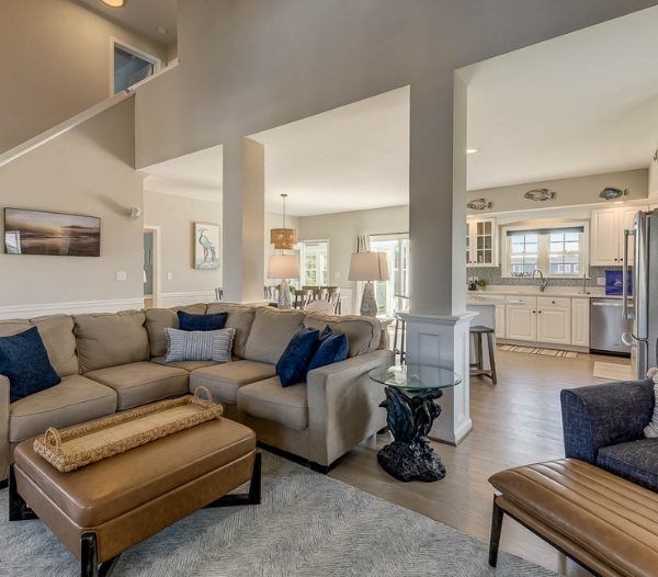 A stylish living room featuring a couch, chair, and ottoman, designed by Kempsville Virginia Beach Homebuilders.