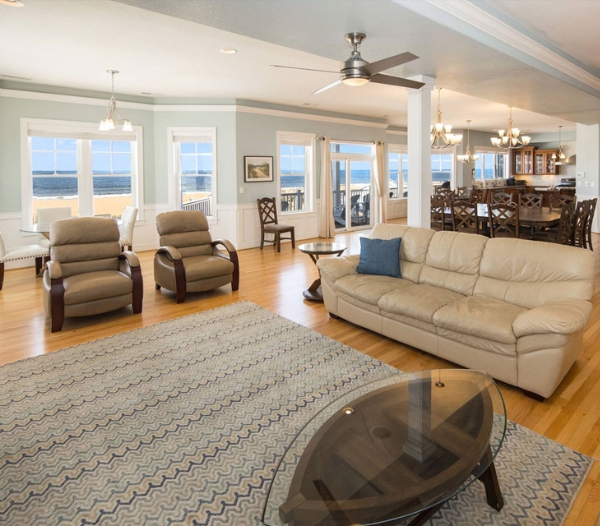 Elegant living room equipped with a couch, chairs, and a television, emphasizing high-quality materials from Ocean Lakes Homebuilders.