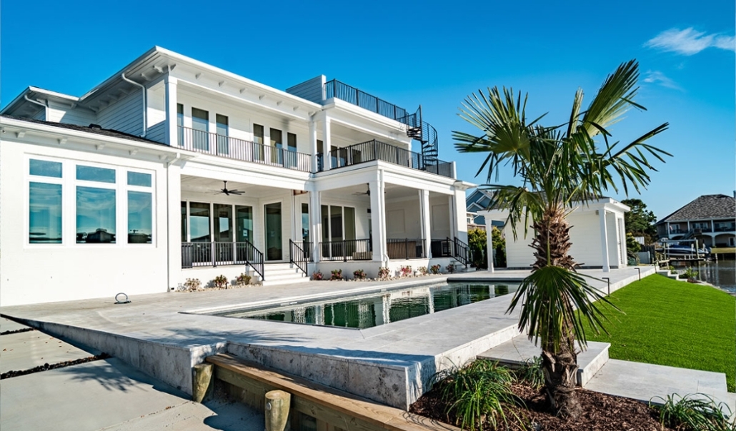 A prominent white residence with a newly installed windows with luxurious outdoor setting.