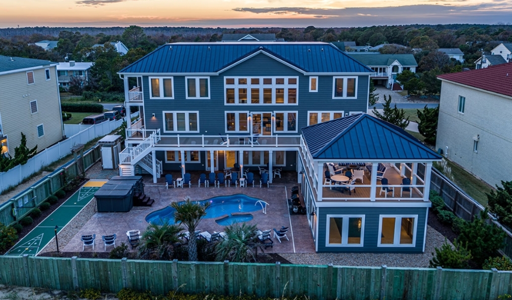 A tranquil home with a pool and deck, set against a vibrant sunset sky, creating a peaceful atmosphere.