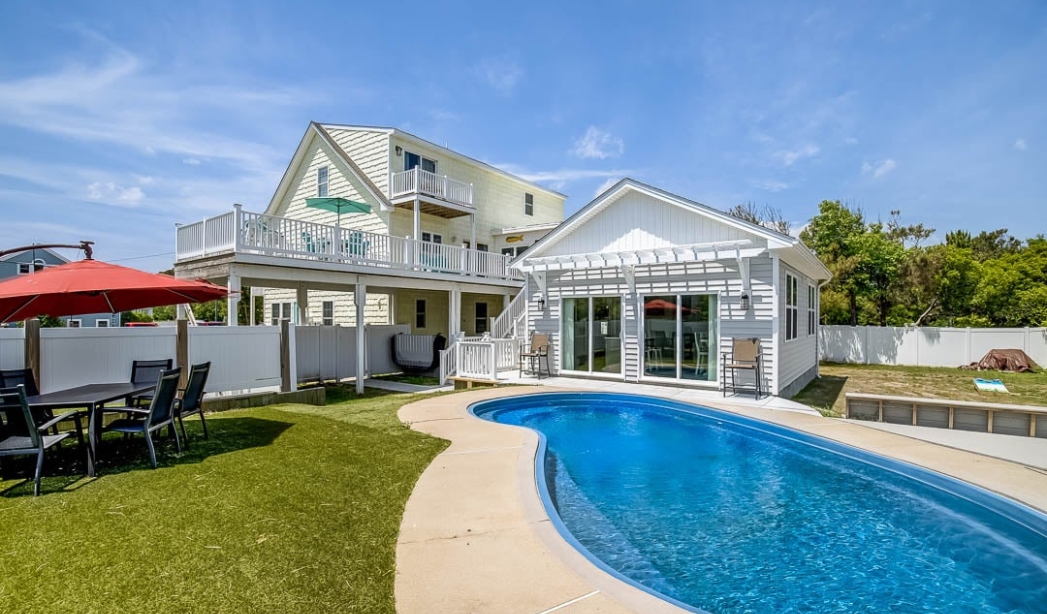 A remodeled house in Virginia Beach featuring a pool and a spacious patio area for outdoor relaxation.