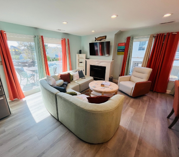 Cozy living room with a couch, chairs, and a television, designed with premium coastal materials in Virginia Beach.