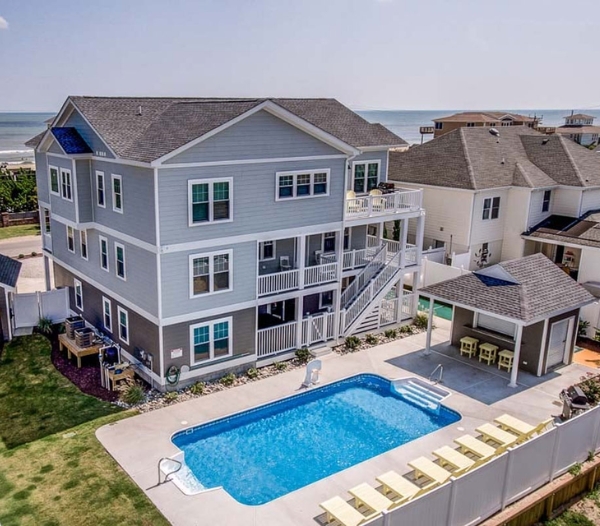 A remodeled house with a pool overlooking the beach, highlighting real estate value in Virginia Beach.