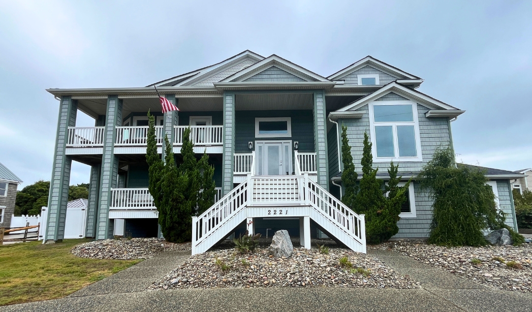 A home featuring stairs that lead up to a welcoming front porch, representing a Virginia Beach home improvement project.