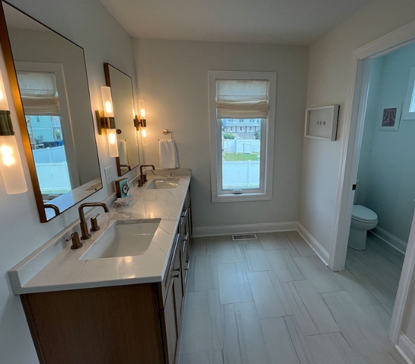 A modern bathroom featuring two sinks and a window, showcasing a clean and spacious design for home improvement.