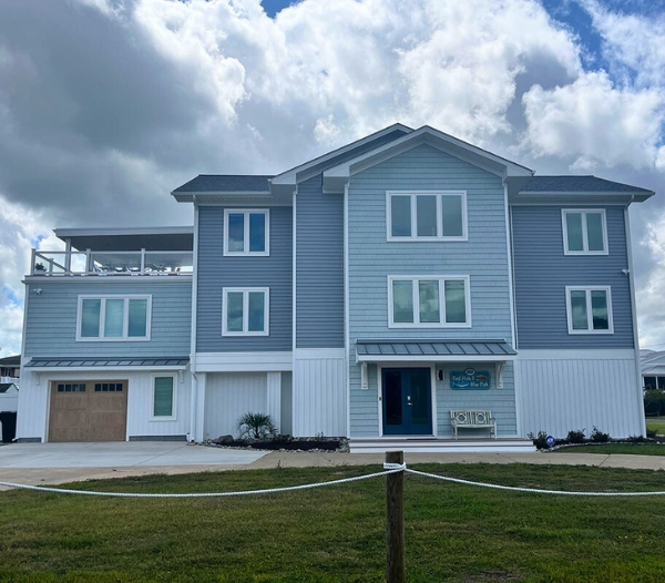 Coastal-style two-story house featuring blue siding and white trim, ideal for enhancing lifestyles in Virginia Beach.