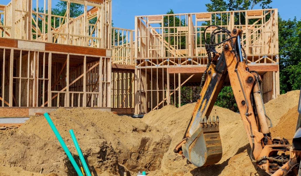 A construction worker digging a hole in the dirt, illustrating the importance of hiring licensed contractors for renovations.