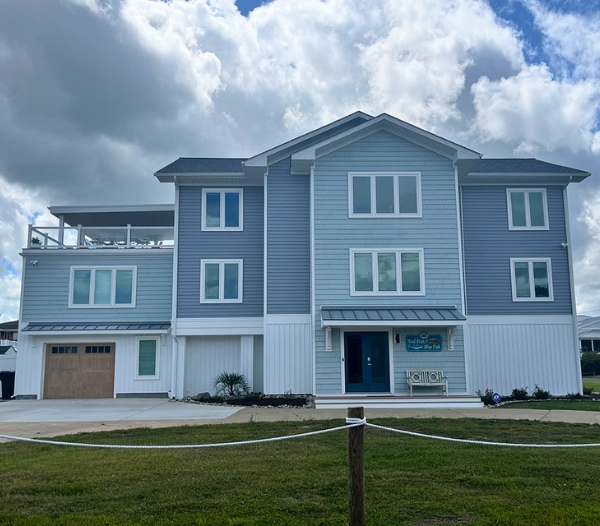 Two-story home with blue siding and white trim, showcasing exterior remodeling for durability and weather protection.